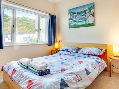 a bedroom with a bed and a window at Mortreth in Porthtowan