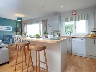 a kitchen with a counter and stools in a room at Semybadazee in Poundstock