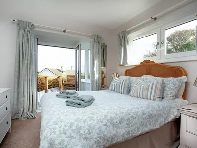 a bedroom with a large bed with towels on it at Semybadazee in Poundstock