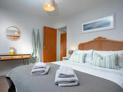 a bedroom with a large bed with towels on it at Semybadazee in Poundstock