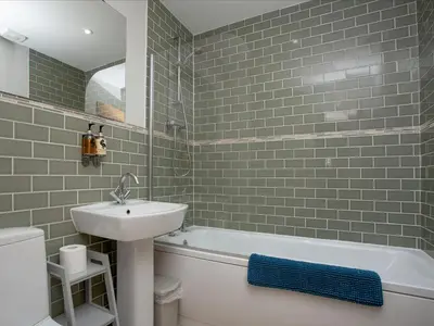 a bathroom with a sink and a toilet and a bath tub at Semybadazee in Poundstock