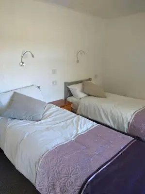 two beds sitting next to each other in a room at Family friendly rural lodge in Truro