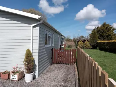 a small house with a fence next to a yard at Family friendly rural lodge in Truro
