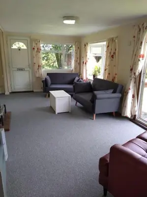 a living room with two couches and a table at Family friendly rural lodge in Truro