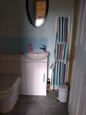 a bathroom with a sink and a shower curtain at Cosy cabin for two in Truro