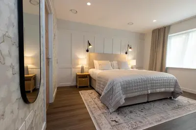 a bedroom with a large bed and a mirror at The Kingswood in St Austell