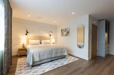 a bedroom with a large bed and a mirror at The Kingswood in St Austell