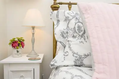 a bedroom with a bed with a pillow and a lamp at Bijou Coastal Apartment in Polperro With Hot Tub, Onsite Parking 5 min Downhill Walk To Village in Polperro