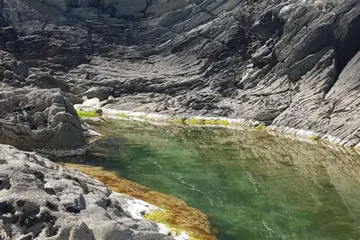 a pool of green water in a rocky mountain at Bijou Coastal Apartment in Polperro With Hot Tub, Onsite Parking 5 min Downhill Walk To Village in Polperro