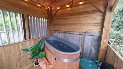 a bath tub in the inside of a wooden sauna at Bijou Coastal Apartment in Polperro With Hot Tub, Onsite Parking 5 min Downhill Walk To Village in Polperro