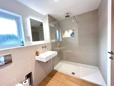 a white bathroom with a sink and a shower at No.48 Falmouth - 10 minutes walk to the beach in Falmouth