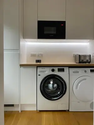 a kitchen with a washing machine and a microwave at No.48 Falmouth - 10 minutes walk to the beach in Falmouth