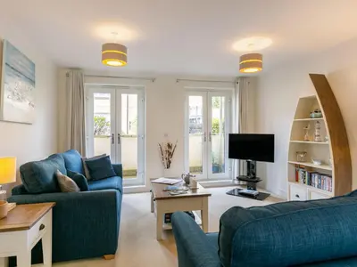 a living room with two blue couches and a tv at Apartment The Saltings by Interhome in St Austell