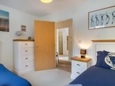 a bedroom with a bed and a wooden door at Apartment The Saltings by Interhome in St Austell