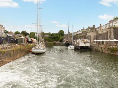 three boats are docked in a canal in a city at Apartment The Saltings by Interhome in St Austell