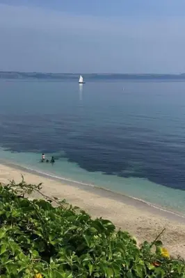 two people are in the water on a beach at Apartment The Saltings by Interhome in St Austell
