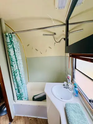 a bathroom with a sink and a mirror at WildView Cosy Glamping with Outdoor Bath and stunning scenery in Helston