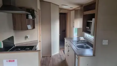 a small kitchen with a sink and a microwave at Newquay Caravan, Newquay Bay Resort Jetts View 104 in Newquay