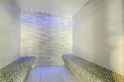 a room with two benches and a wall with water at Newquay Caravan, Newquay Bay Resort Jetts View 104 in Newquay