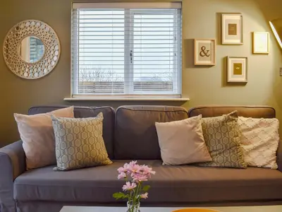 a couch with pillows in a living room with a window at High View in Truro