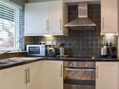 a kitchen with white cabinets and a microwave at High View in Truro