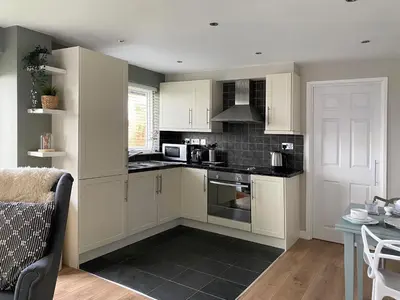 a kitchen with white cabinets and a stove top oven at High View in Truro
