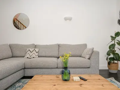 a living room with a gray couch and a wooden coffee table at Zephyr in Helston