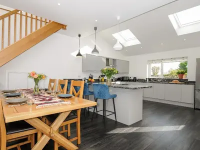 a kitchen and dining room with a wooden table and chairs at Zephyr in Helston