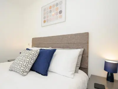 a bedroom with a bed with white and blue pillows at Zephyr in Helston