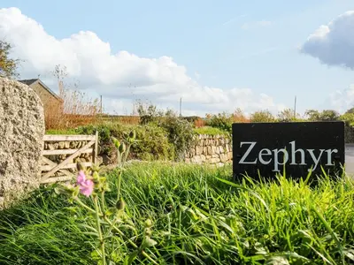 a sign in the grass in front of a yard at Zephyr in Helston