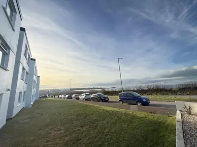 a row of cars parked on the side of a road at 18 Coastline apartment in Newquay
