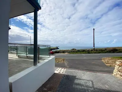 a building with a view of a parking lot and the ocean at 2 Watergate View in Newquay