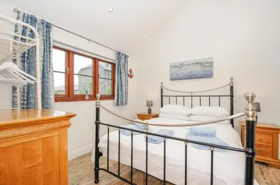 a bedroom with a bed and a desk at Pol Glas Cabin in Helston