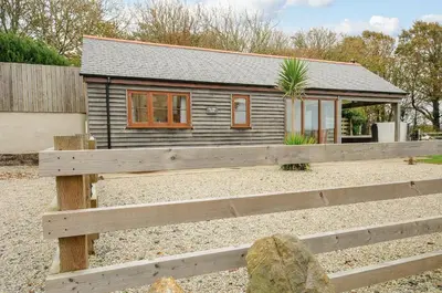 a small house with a fence in front of it at Pol Glas Cabin in Helston