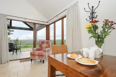 a dining room with a table with food on it at Pol Glas Cabin in Helston