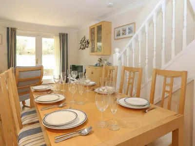 a wooden table with plates and wine glasses on it at Morton Cottage in Falmouth