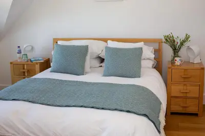 a bedroom with a bed with blue and white pillows at St Helen’s House in Padstow