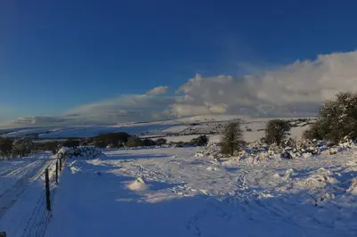 a snow covered field with a fence in a field at Skyber Barn, a rural retreat on Bodmin Moor in Liskeard