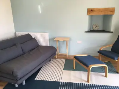 a living room with a couch and two chairs at Skyber Barn, a rural retreat on Bodmin Moor in Liskeard