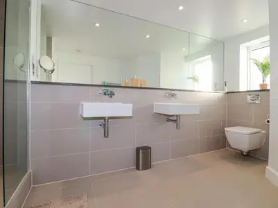 a bathroom with two sinks and a toilet at Fistral Retreat in Newquay