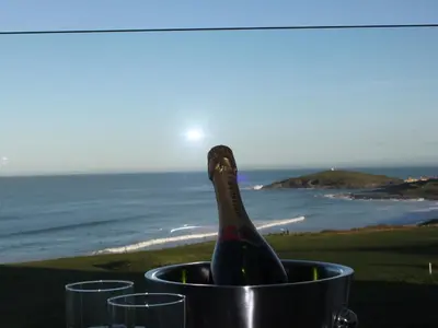 a bottle of wine in a bucket with glasses at Fistral Retreat in Newquay