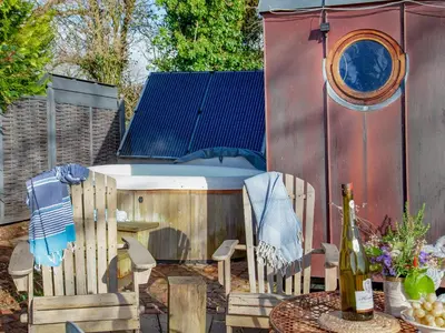 a backyard with a hot tub and a table and chairs at The Observatory-Uk41754 in Lanreath