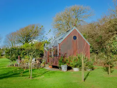 an old red barn in a field with trees at The Observatory-Uk41754 in Lanreath