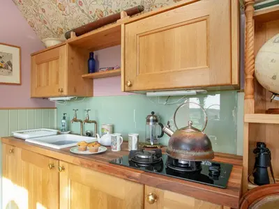 a kitchen with a stove with a tea kettle on it at The Observatory-Uk41754 in Lanreath