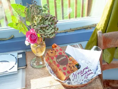 a table with a basket of cookies and a vase with flowers at The Tabernacle-Uk41753 in Lanreath