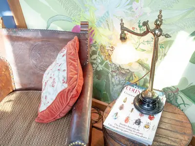 a lamp on a table next to a pillow and a book at The Tabernacle-Uk41753 in Lanreath