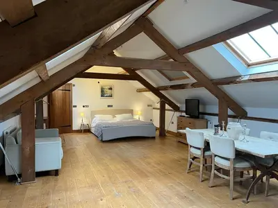 a bedroom with a bed and a table and chairs at The Old Stable - Flat 1 in Wadebridge