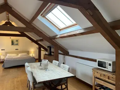 a living room with a table and a bed at The Old Stable - Flat 1 in Wadebridge