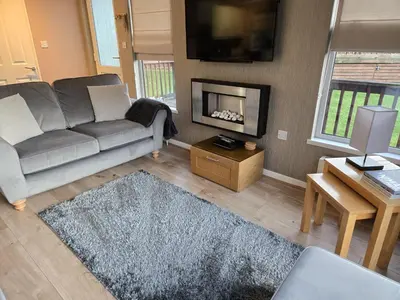 a living room with a couch and a fireplace at Mariners Lodge in Saint Minver