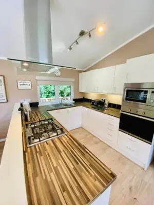 a kitchen with white cabinets and a stove top oven at Mariners Lodge in Saint Minver